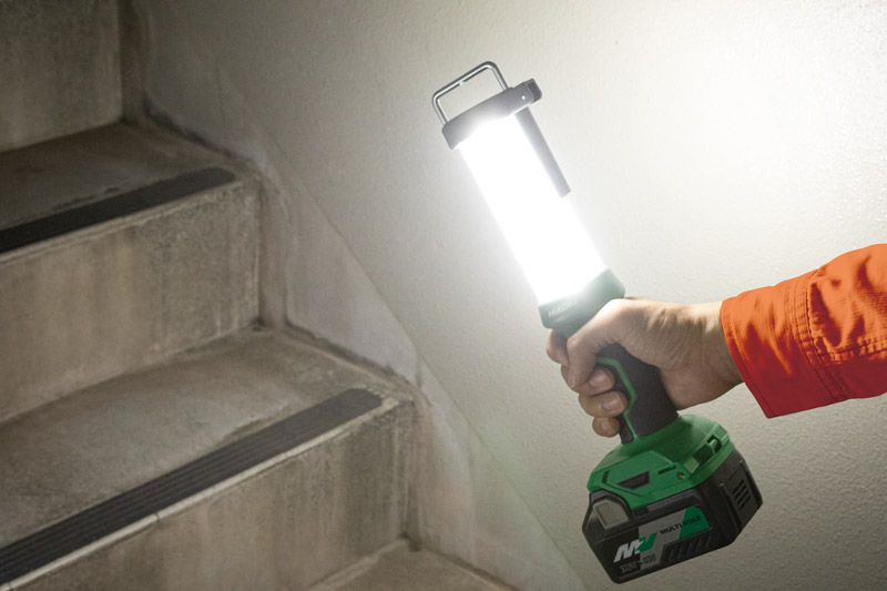 Holding it in the hand and illuminating the staircase.